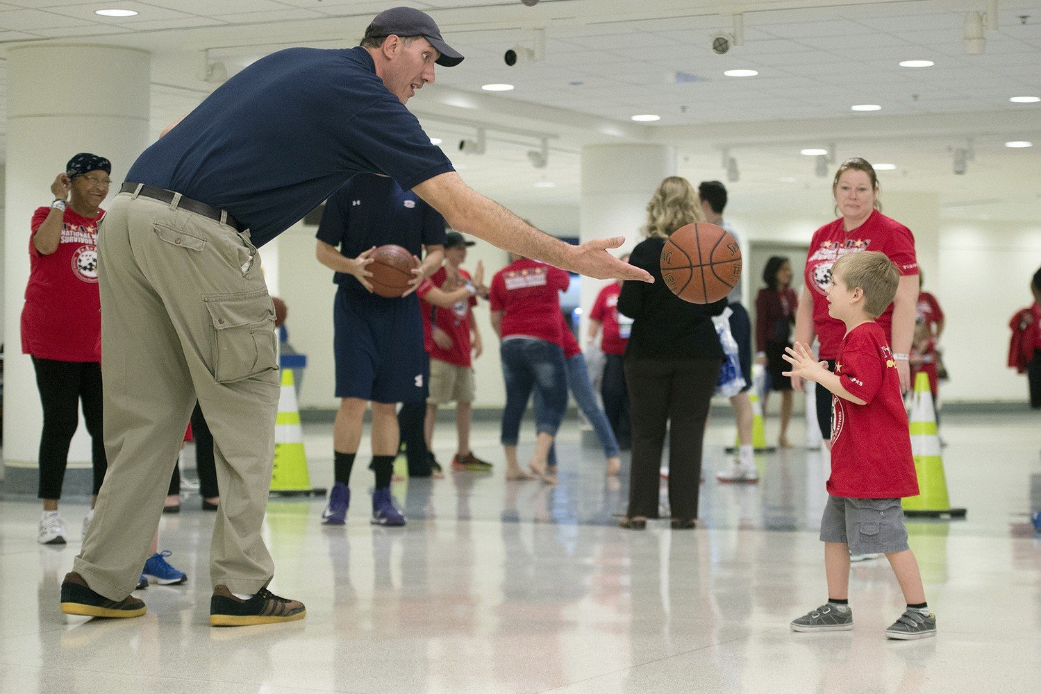 Former NBA player Gheorghe Mure?an tosses a basketball to a child 