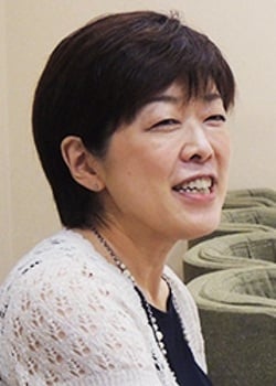 An image of Yasuko Kobayashi on a beige background